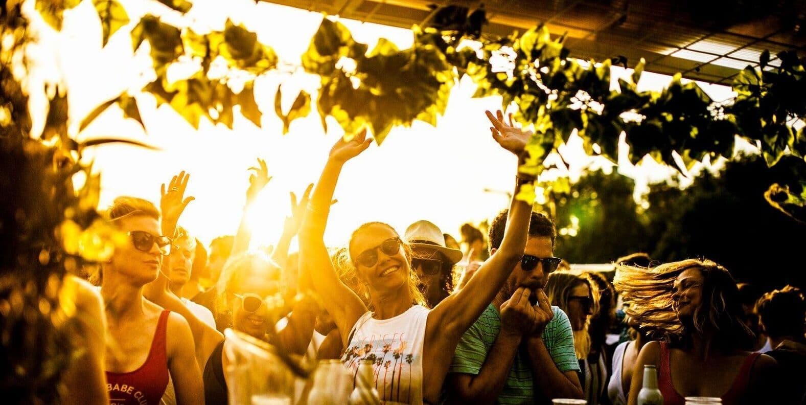 Curfew crowd dancing under golden hour light